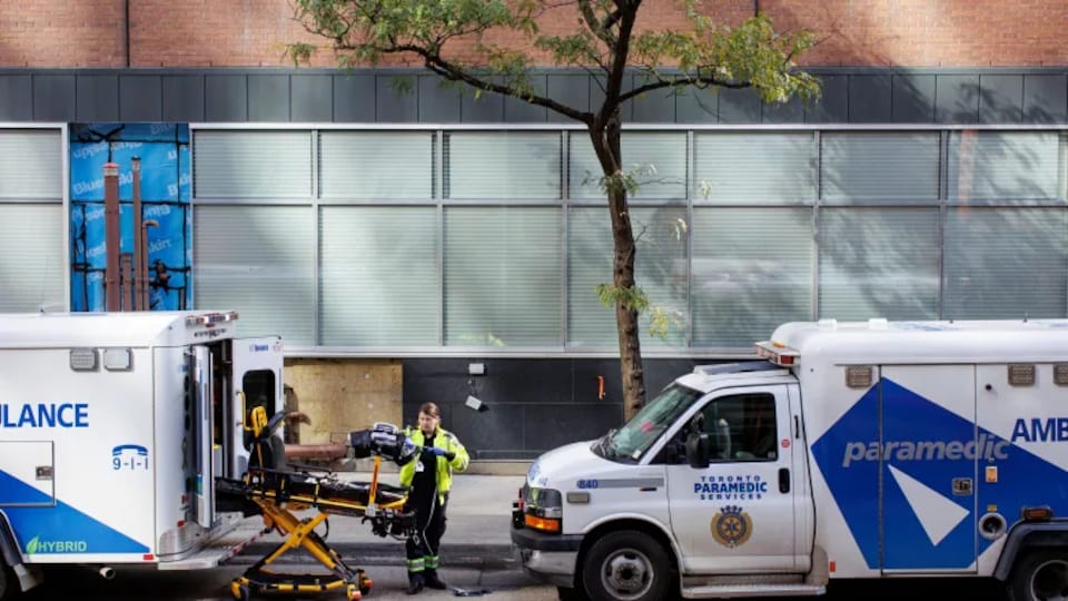 A paramedic is pictured near ambulances outside St. Michael's Hospital in Toronto on Friday. A recent Ontario Health report outlined the immense pressure on the province's emergency rooms. (Evan Mitsui/CBC)